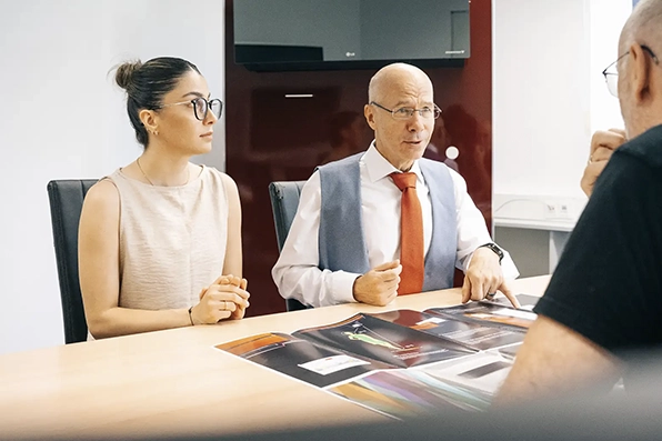 Zwei Personen in einem Business-Meeting, diskutieren technische Dokumente