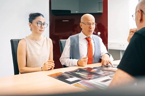 Zwei Personen in einem Business-Meeting, diskutieren technische Dokumente von Klimatechnik Wagner aus Augsburg.